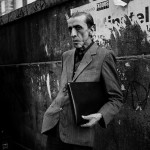 A man is waiting for the bus at a vandalised bus top inb Palermo. March 2009